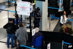ARCHIVO - Un letrero advierte a los viajeros que no traigan armas a través del punto de control de la Administración de Seguridad del Transporte en el Aeropuerto Internacional O'Hare en Chicago, el 19 de diciembre de 2022.