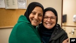 Bibi Bahrami y su amiga cercana, la Dra. Miriam Ibrahim, se abrazan en el Centro Islámico de Muncie, Indiana, el 3 de marzo de 2023. Bahrami es el tema del documental. "Extraño en la puerta."