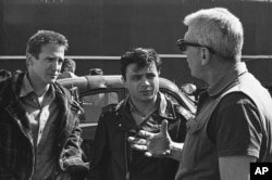 ARCHIVO - El director Richard Brooks, a la derecha, hace un comentario mientras habla con los actores Scott Wilson, a la izquierda, y Robert Blake durante el rodaje de la adaptación del libro. "En sangre fria" en marzo de 1967 en Kansas City, Kansas.