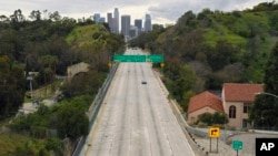 ARCHIVO - El tráfico extremadamente ligero se mueve a lo largo de la autopista 110 Harbor Freeway hacia el centro de Los Ángeles a media tarde del 20 de marzo de 2020.